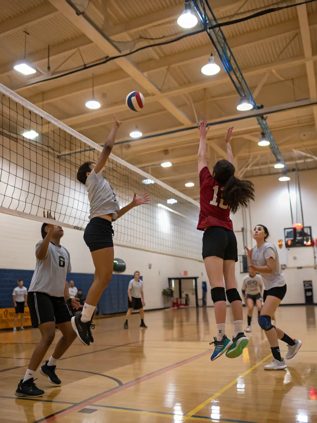 A volleyball team practicing serves and spikes in the school sports hall, emphasizing technique and coordination under ASJA's guidance.